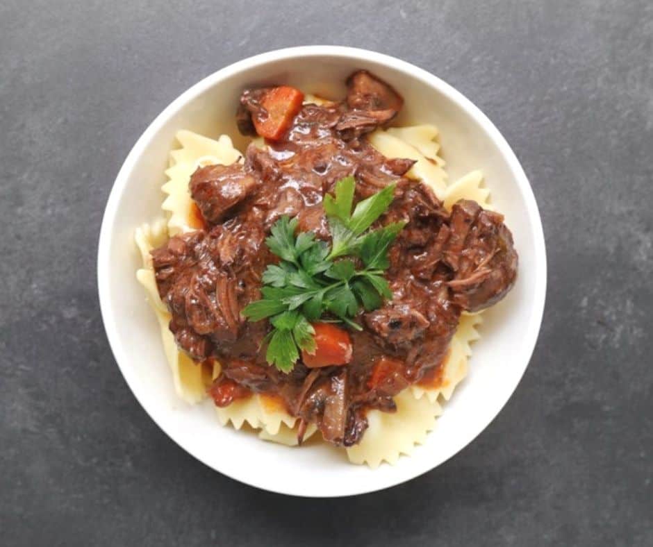 a bowl of Low FODMAP beef bourguignon over pasta