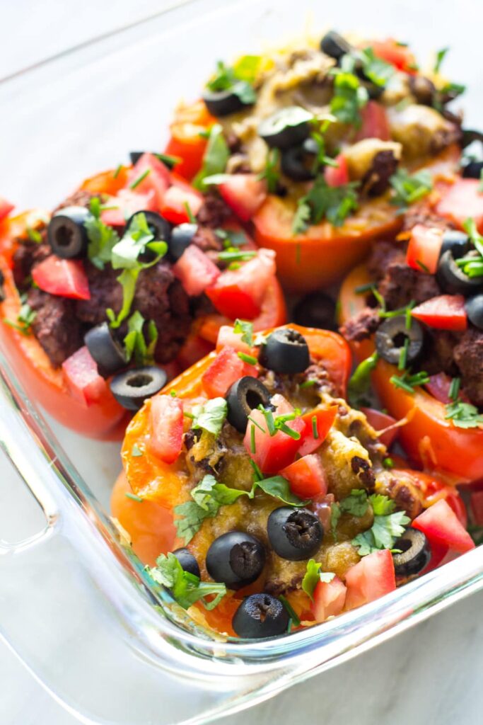 a platter of Low FODMAP taco stuffed peppers with cheese and olives